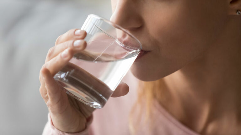 woman drinking water to be hydrated