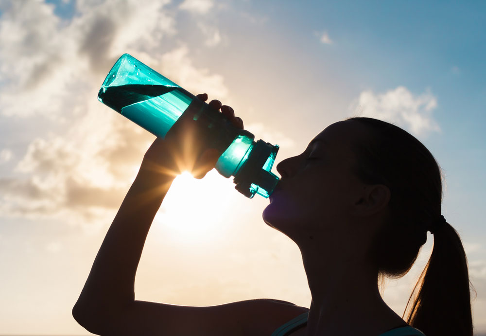 woman drinking from her water bottle