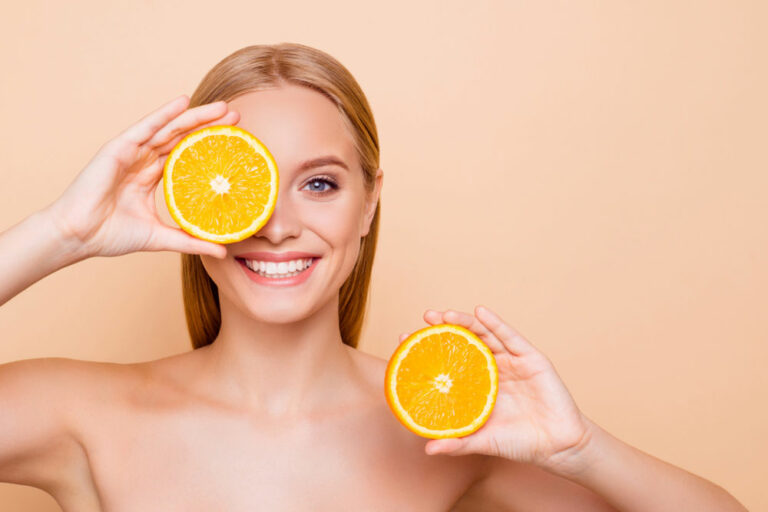 woman holding two oranges up to her head