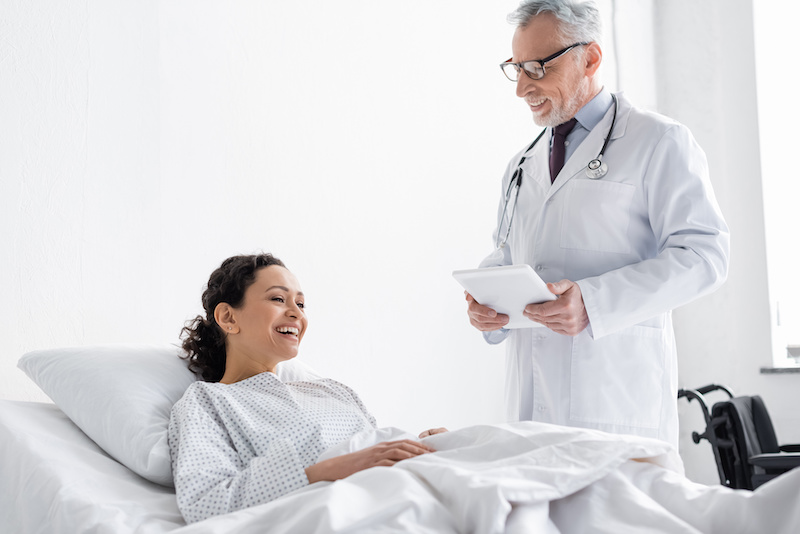 Woman post surgery speaking with doctor