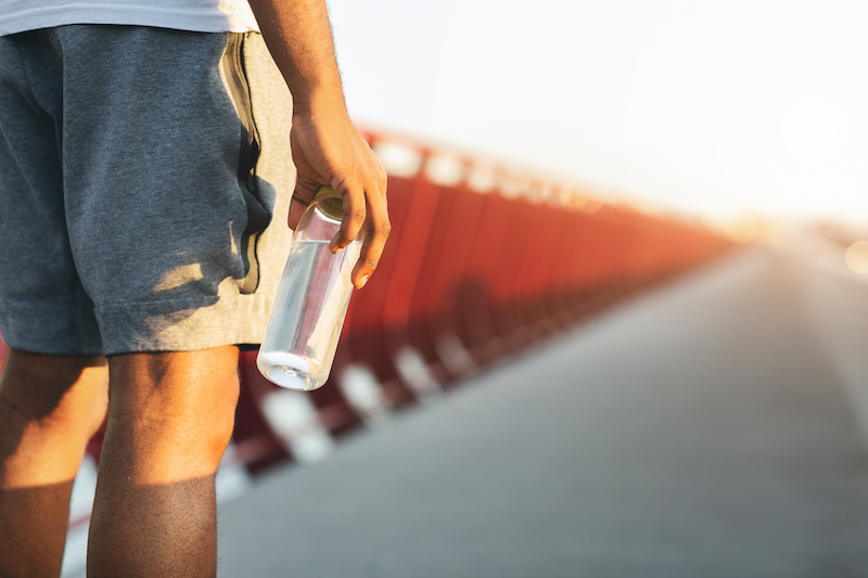 Athlete outside holding a bottle of water